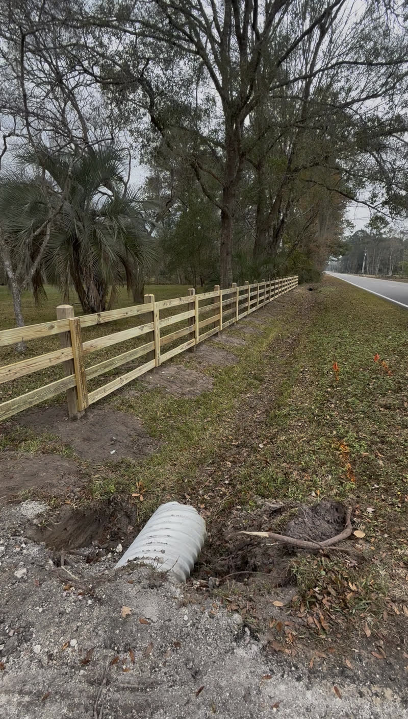 Three rail wooden farm fence following a rural roadside in Northeast Florida